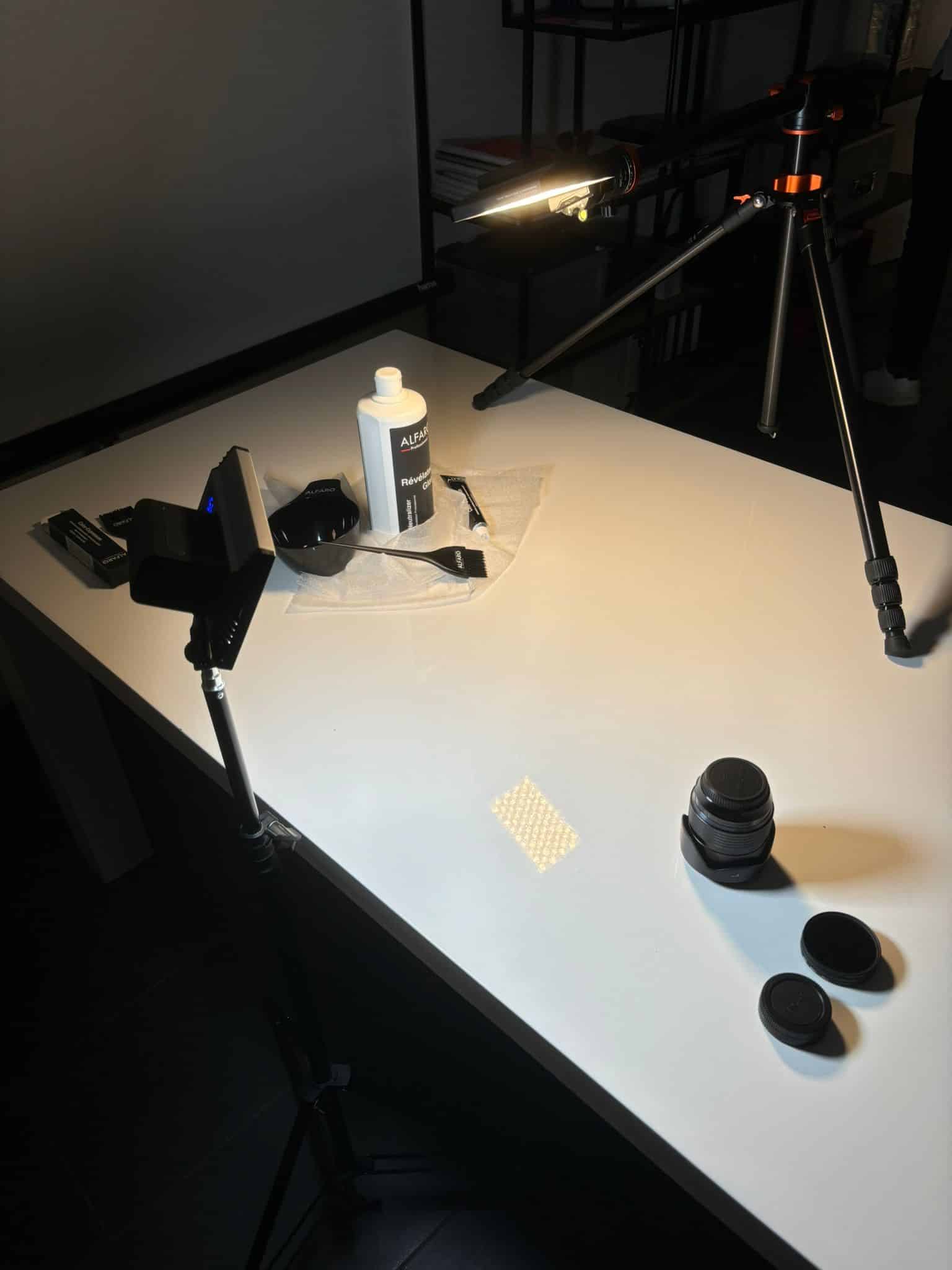 Objectif photo et ses bouchons posés sur la table de prise de vue, dans la lumière